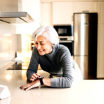 Homeowner using a home automation device in her kitchen