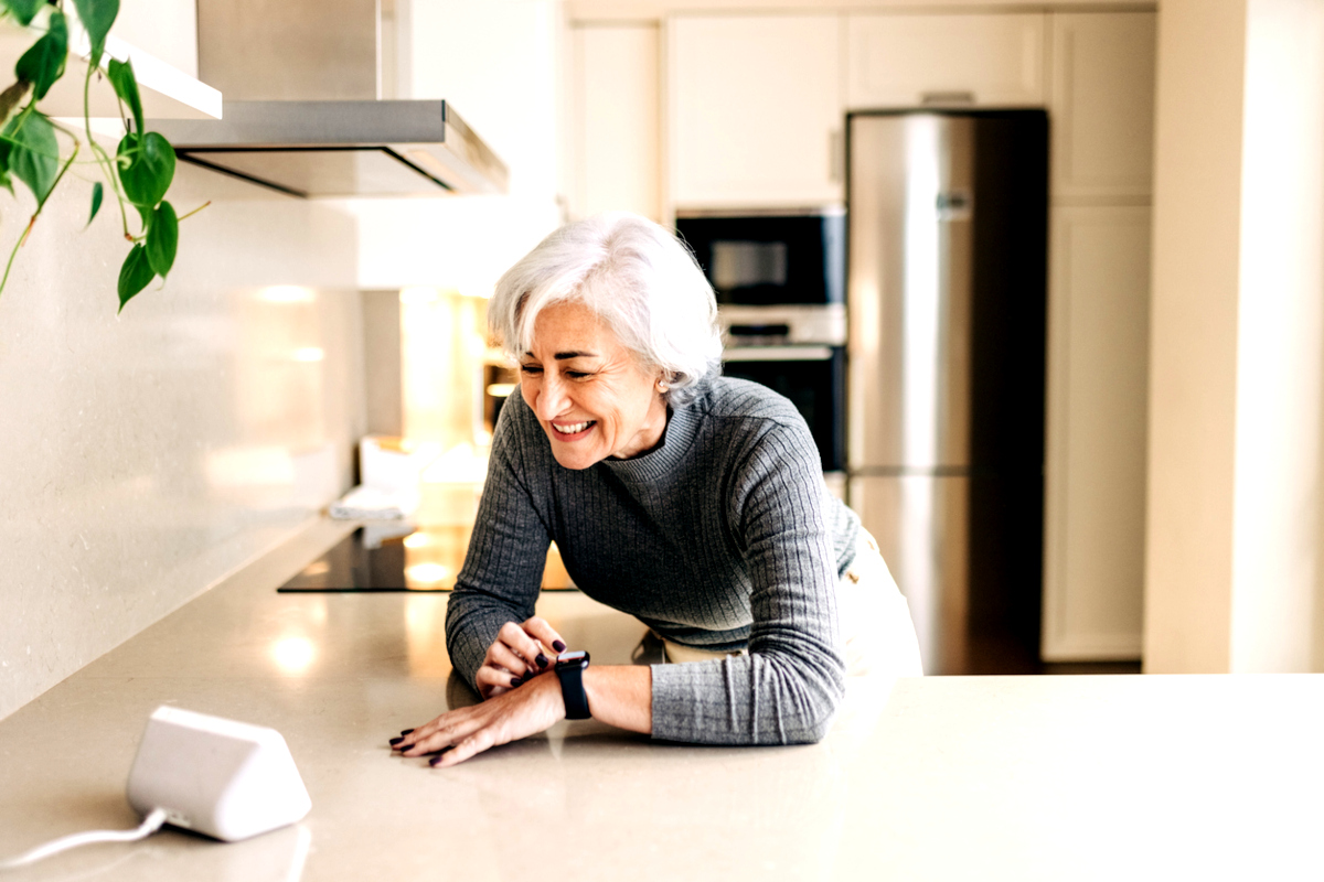 Homeowner using a home automation device in her kitchen