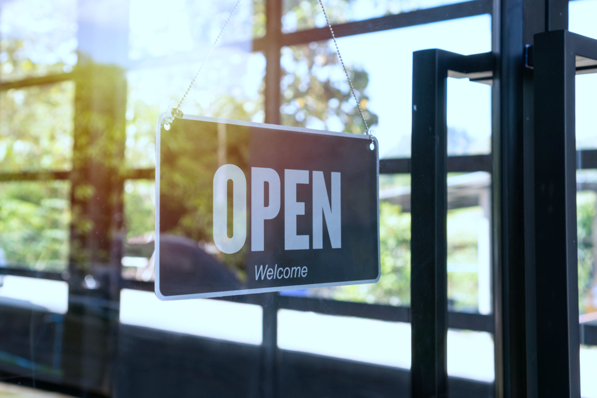 Open sign hanging front of small business building.